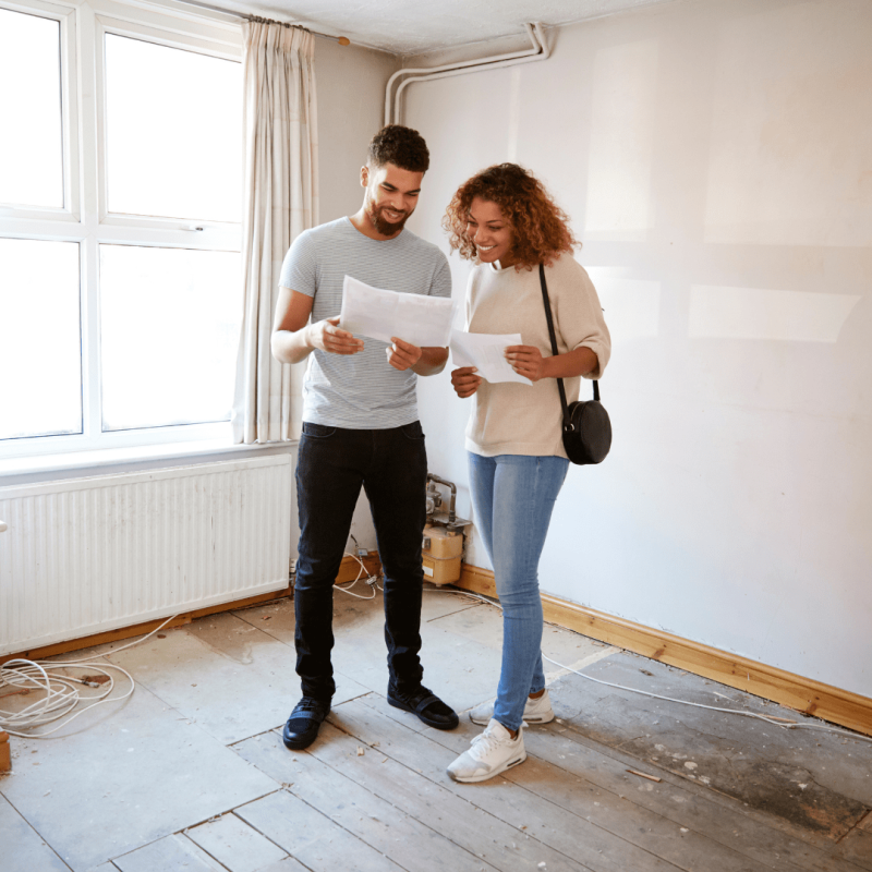 people looking at pieces of paper in new house